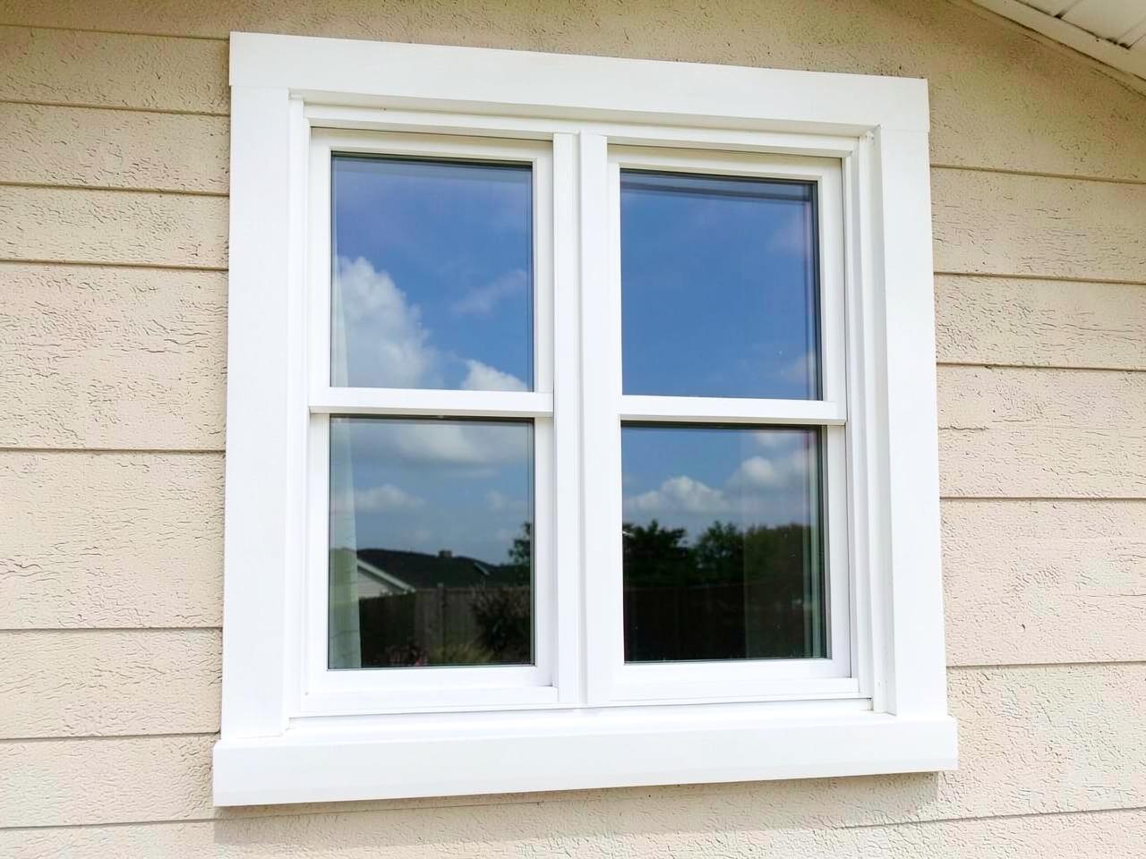 A new white double-hung replacement window set into light siding, seen from outside
